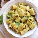 bowl of pesto garlic pasta with a fork scooping a bite.