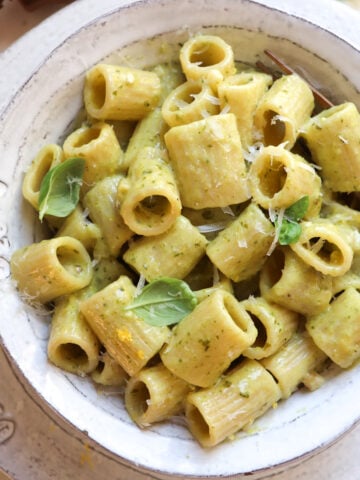 bowl of pesto garlic pasta with a fork scooping a bite.