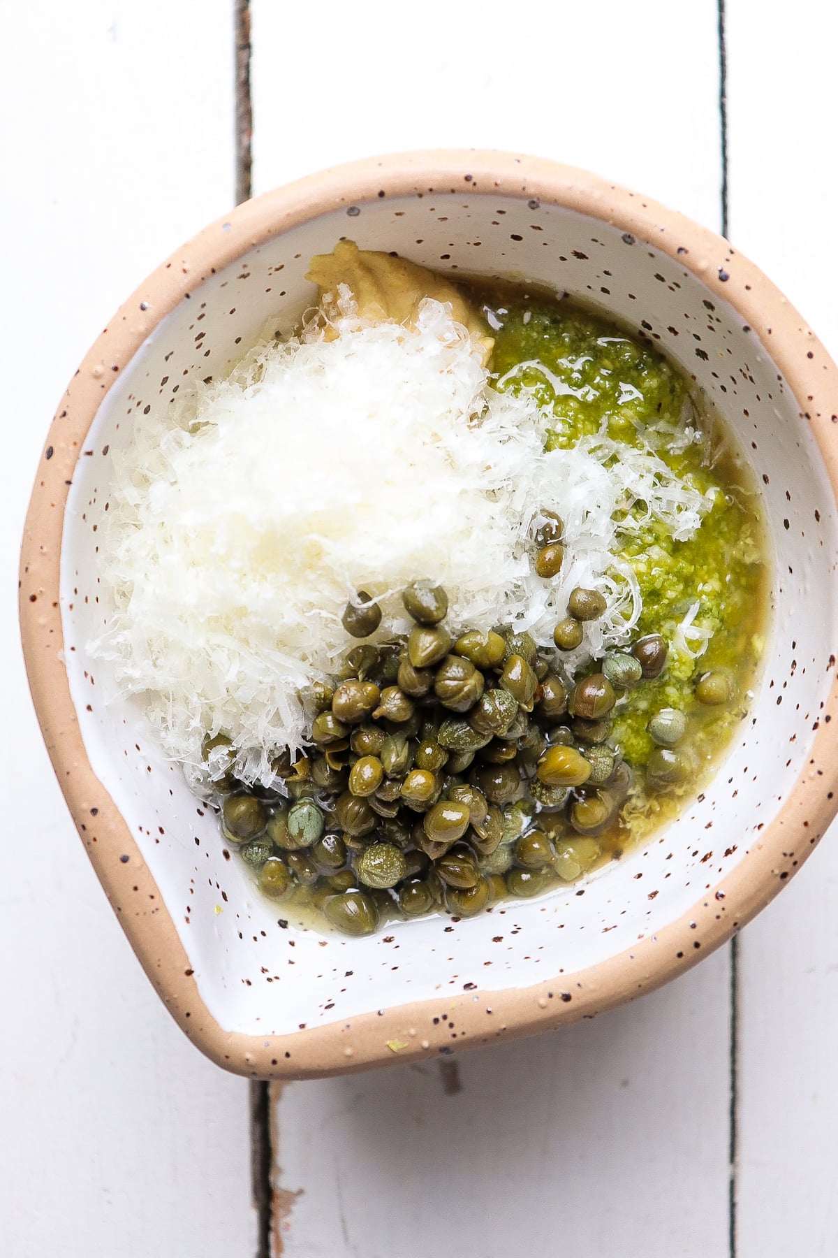 all ingredients added to a small white bowl but unmixed.