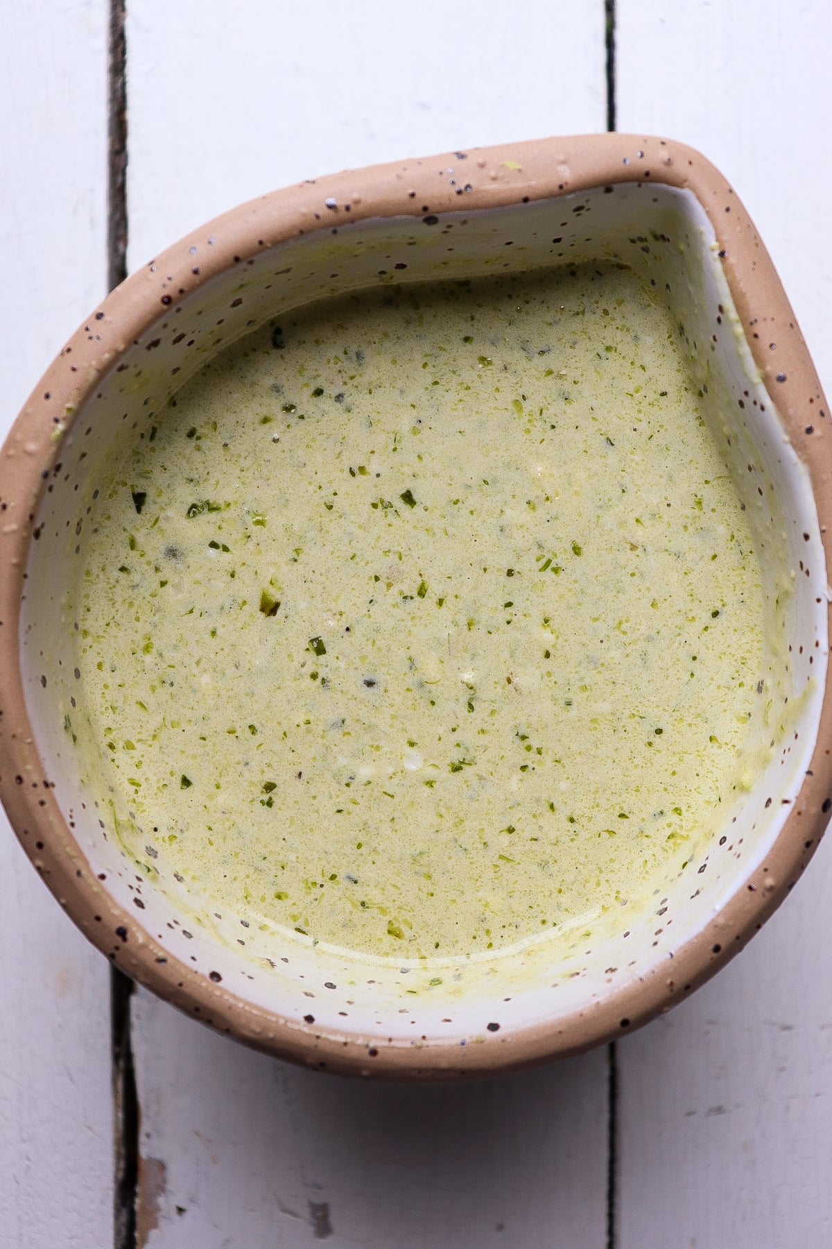 finished pesto caper sauce in a white bowl.