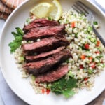 featured image on a bed of couscous topped with sliced skirt steak.