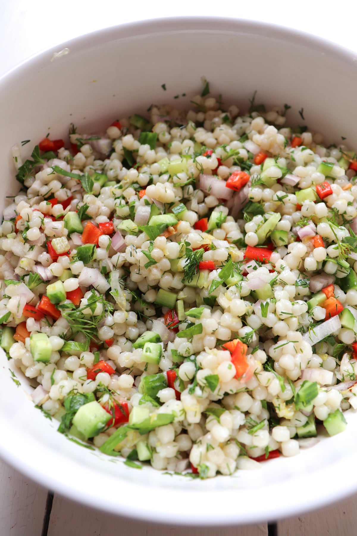 couscous salad in a white bowl.
