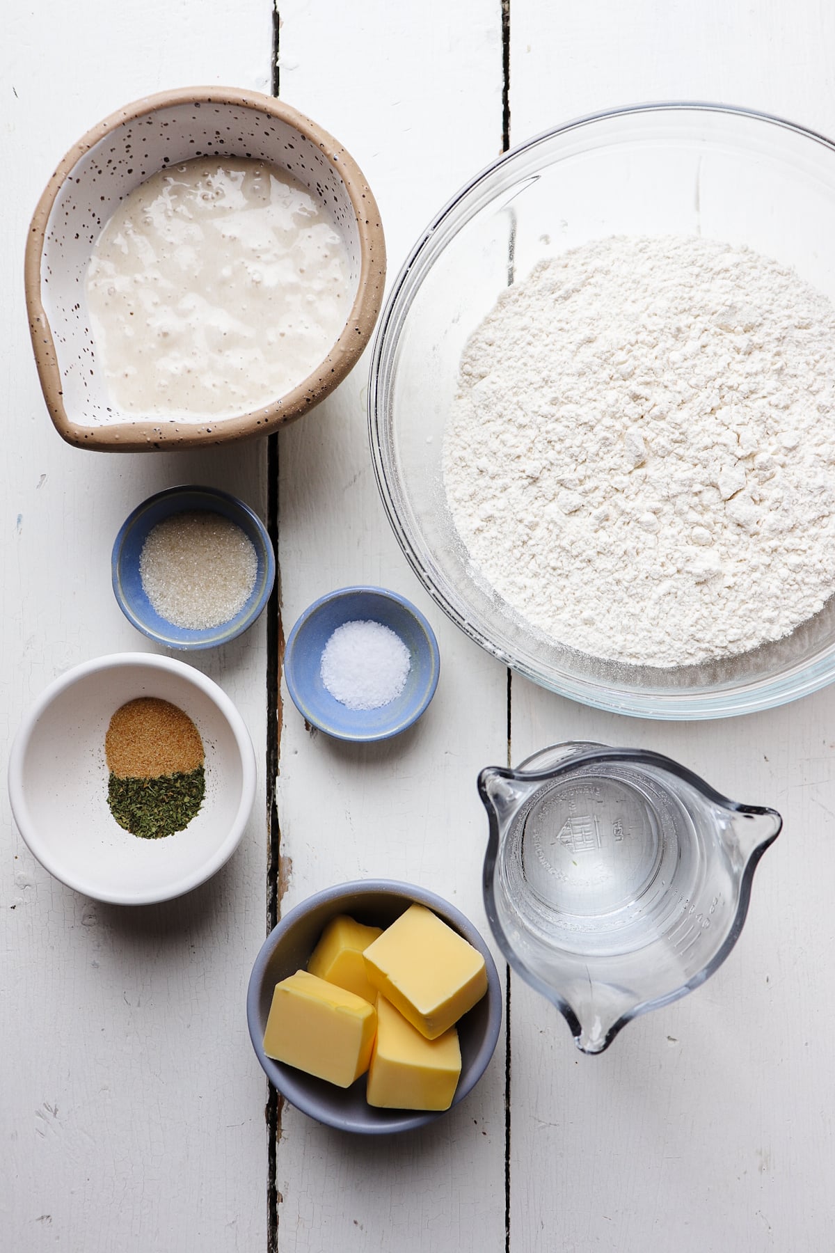 ingredients for sourdough breadsticks on a white table.