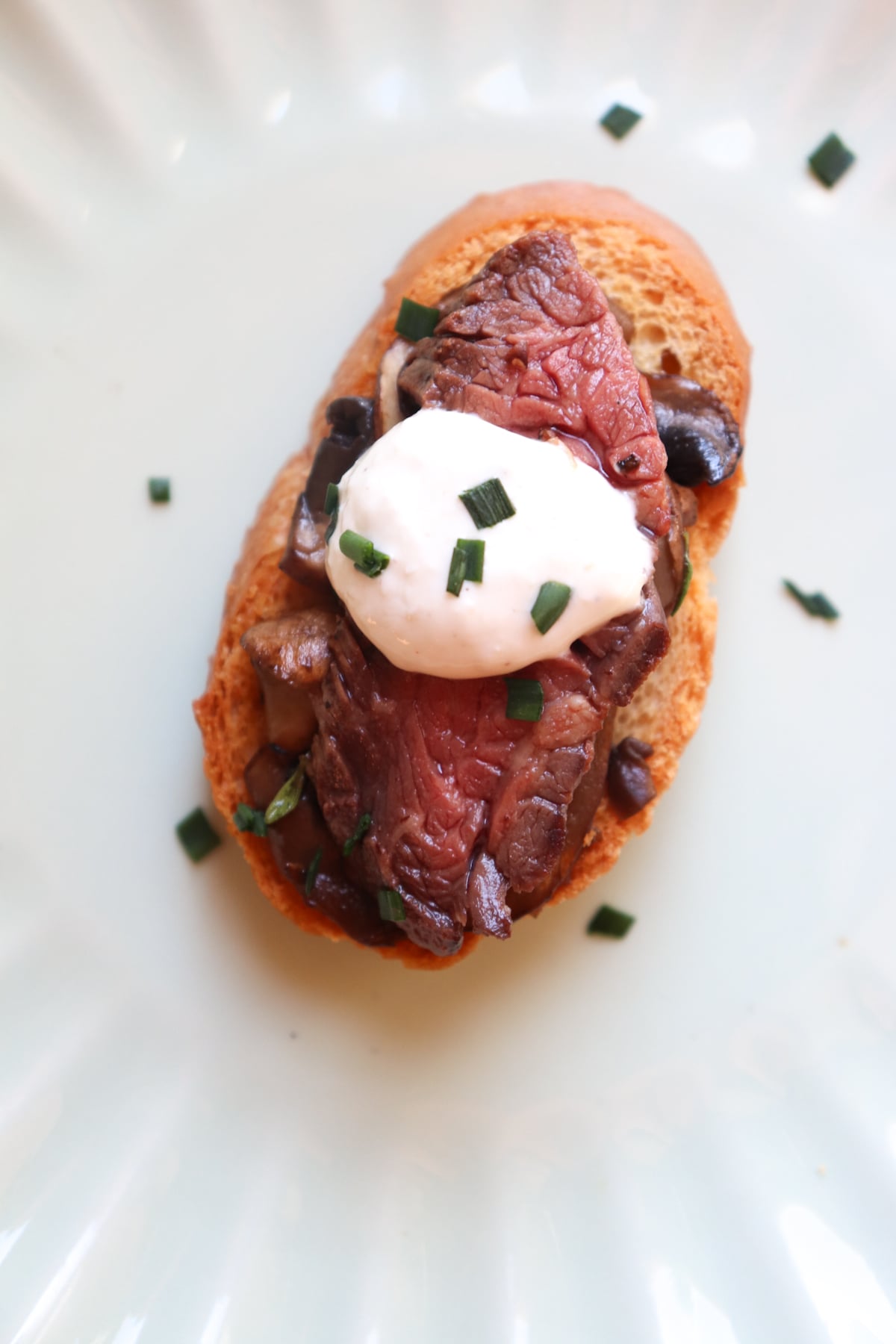 one steak crostini with horseradish cream on a plate.