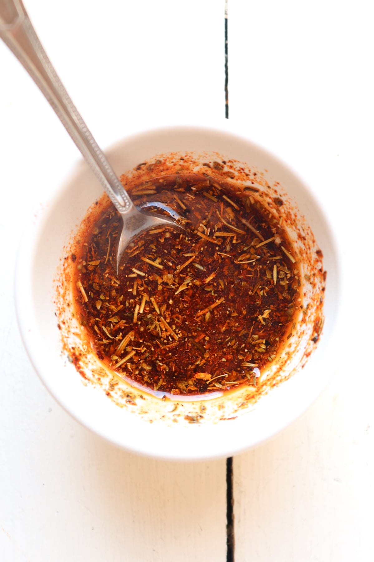 seasoning blend for boneless skinless chicken thighs in a small white bowl.