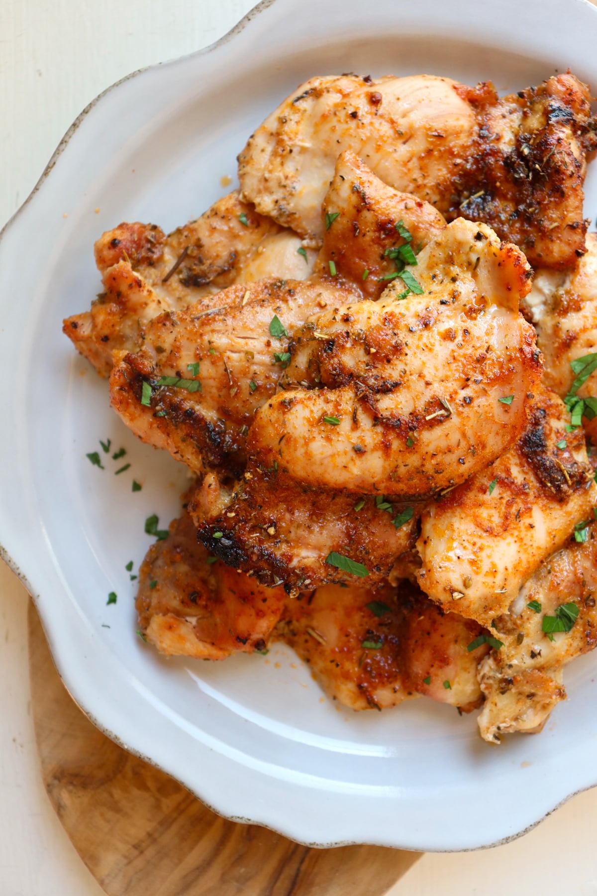 finished boneless skinless chicken thighs on a white plate.