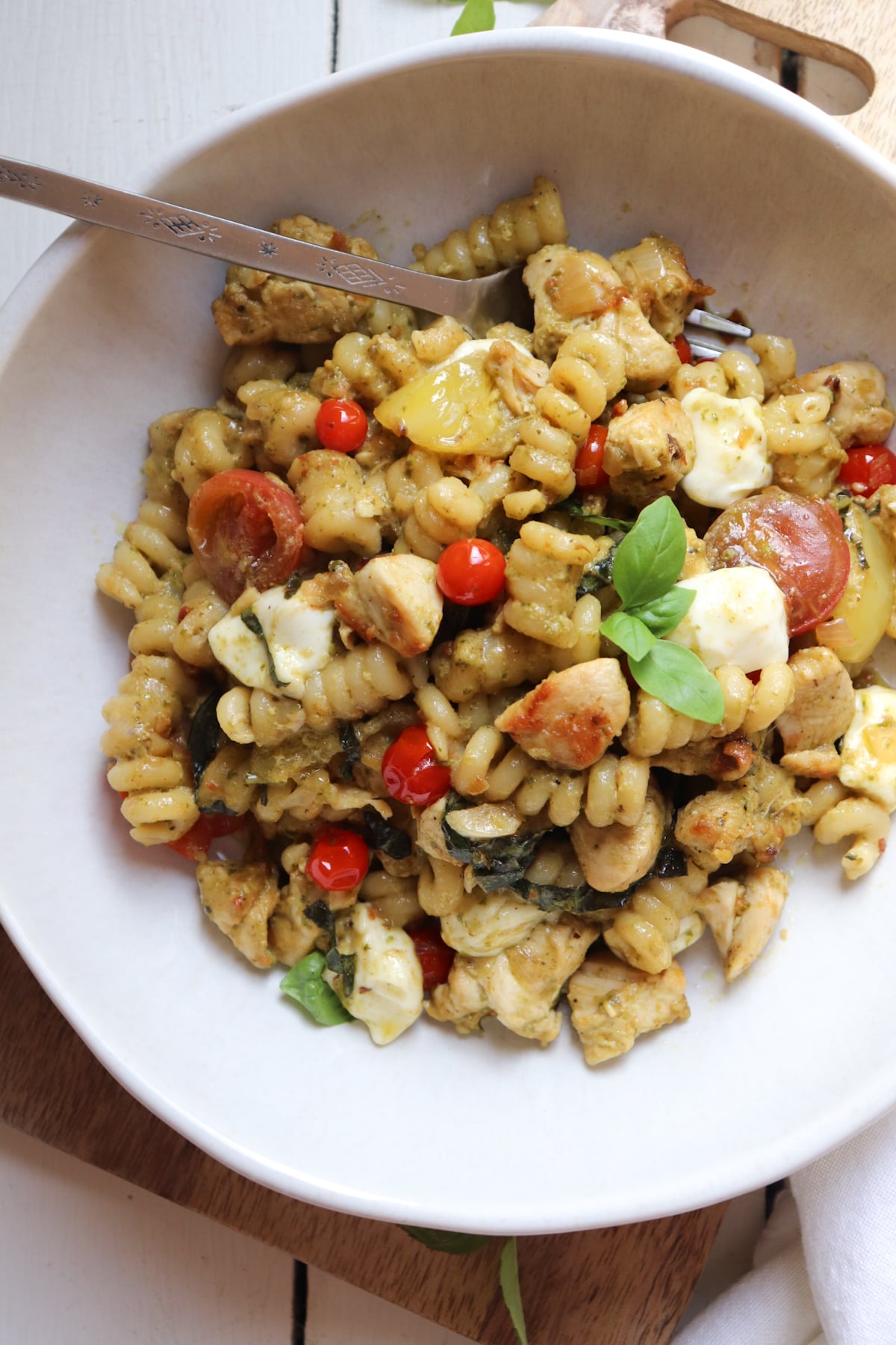 bowl of chicken and pesto pasta with a fork.