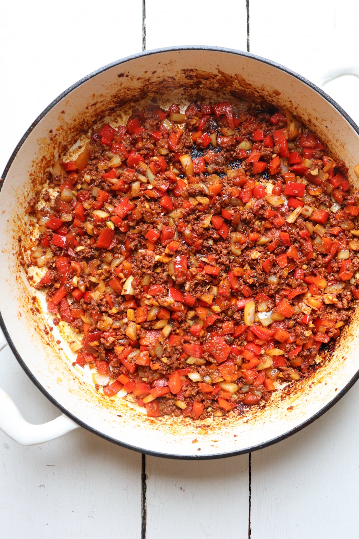 sauteed peppers, onions, and garlic along with chorizo in a pan.