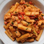 featured image for creamy chorizo pasta with chicken pieces in a white bowl.