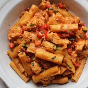 featured image for creamy chorizo pasta with chicken pieces in a white bowl.