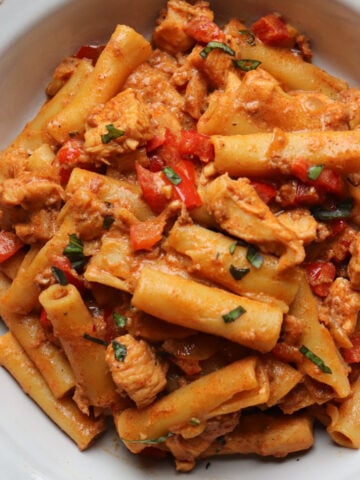 featured image for creamy chorizo pasta with chicken pieces in a white bowl.