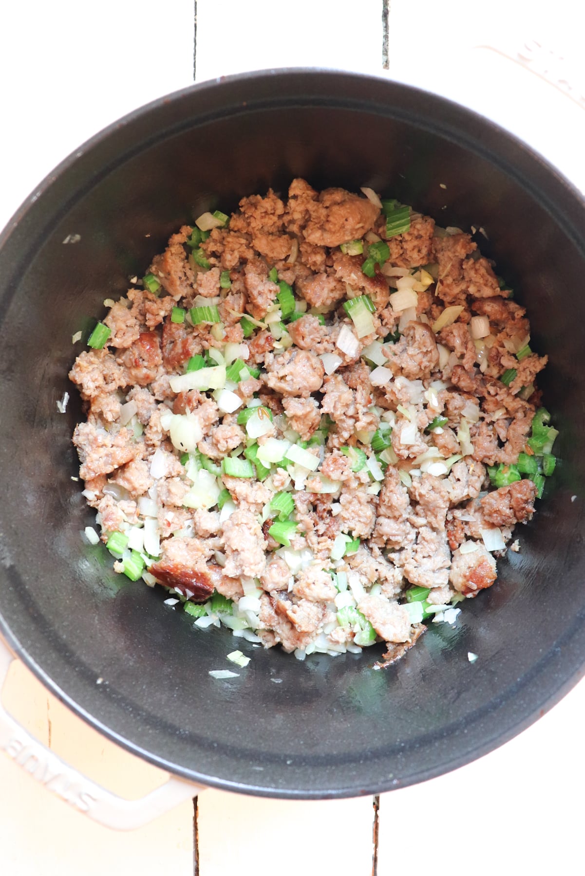 sausage, onions, and celery sauteing in pot.