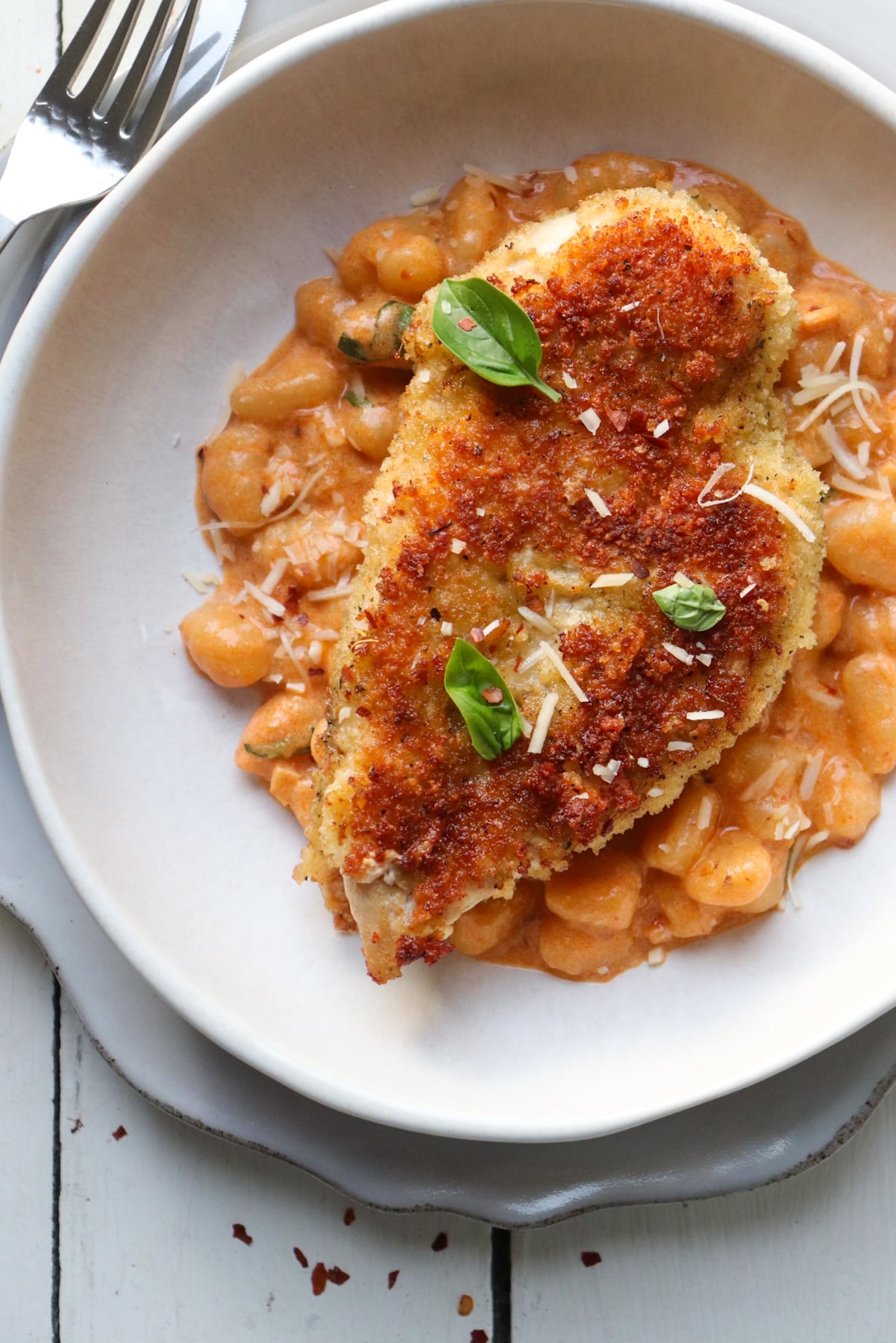 crispy chicken cutlet on bed of creamy gnocchi.