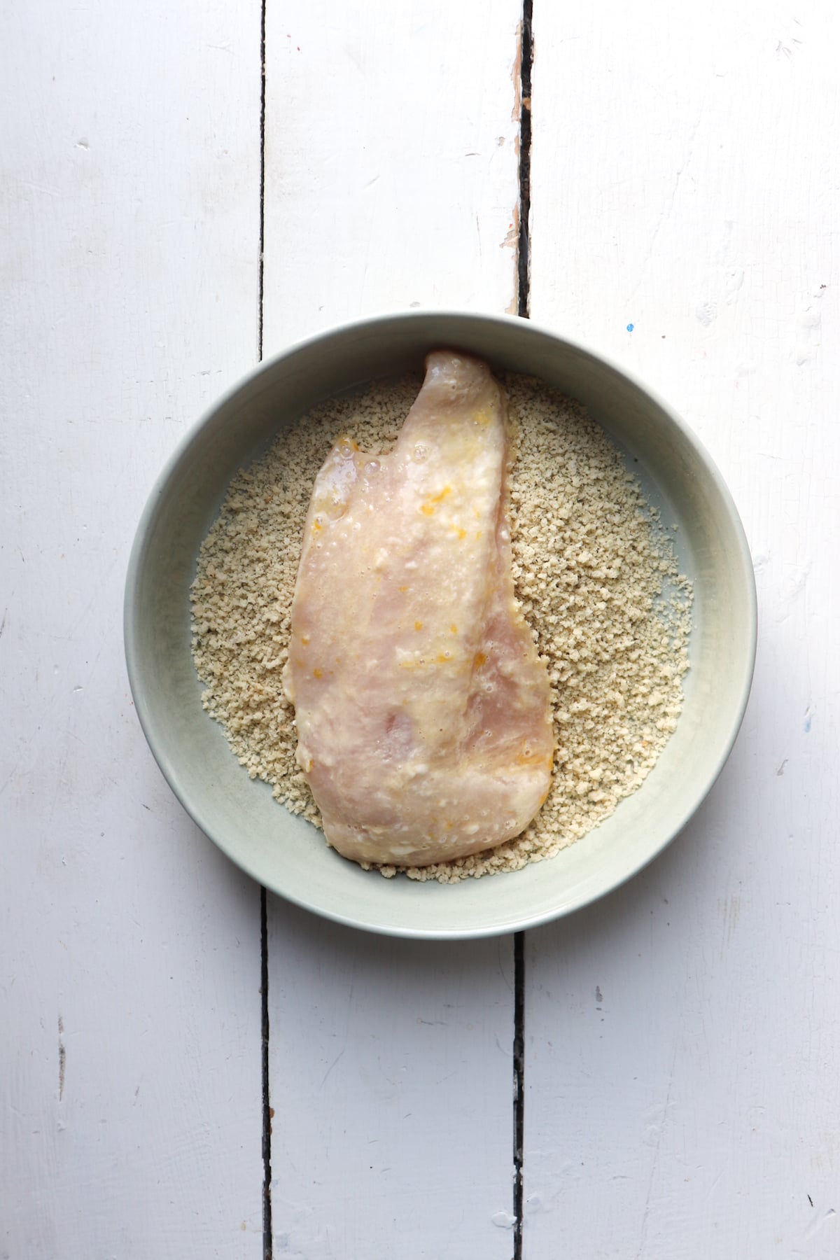 egg washed chicken added to breadcrumbs.